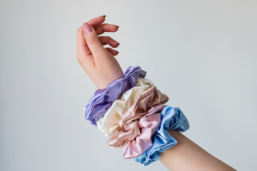 Silk elastic bands on womans arm. Luxury colors.