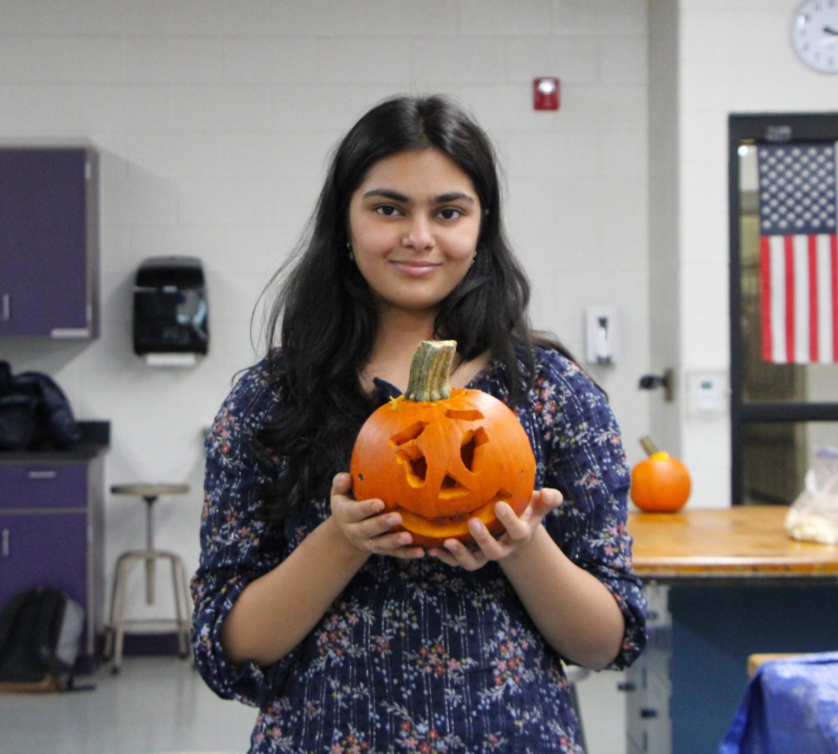 Zaina Javaid carves out a cute jack-o'-lantern.