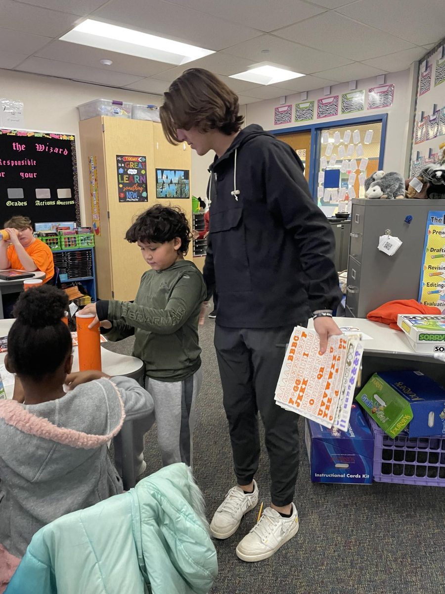 Logan Menge helps Mrs. Regan's class during financial literacy day.