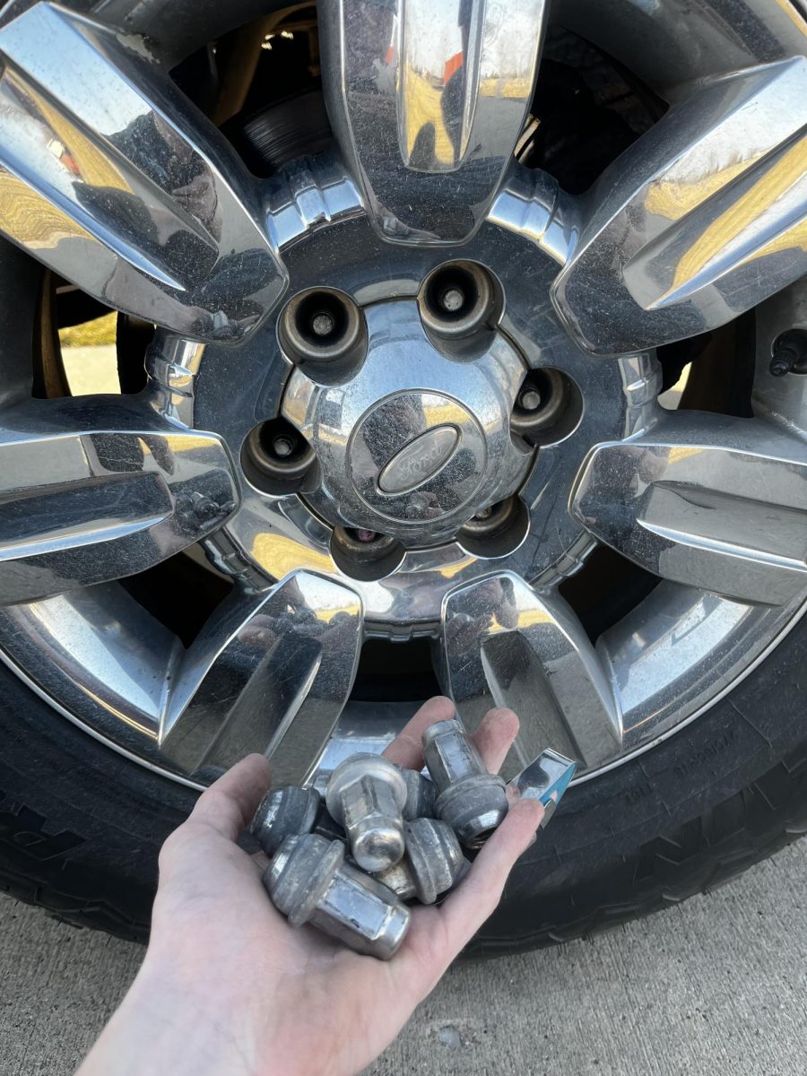 Now that the tire in need is suspended in the air, fully remove the lug nuts.